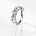 Emerald-cut moissanite half eternity band in rhodium plated sterling silver, upright side view showing the settings and plain band.