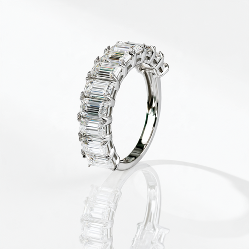 Emerald-cut moissanite half eternity band in rhodium plated sterling silver, upright side view showing the settings and plain band.